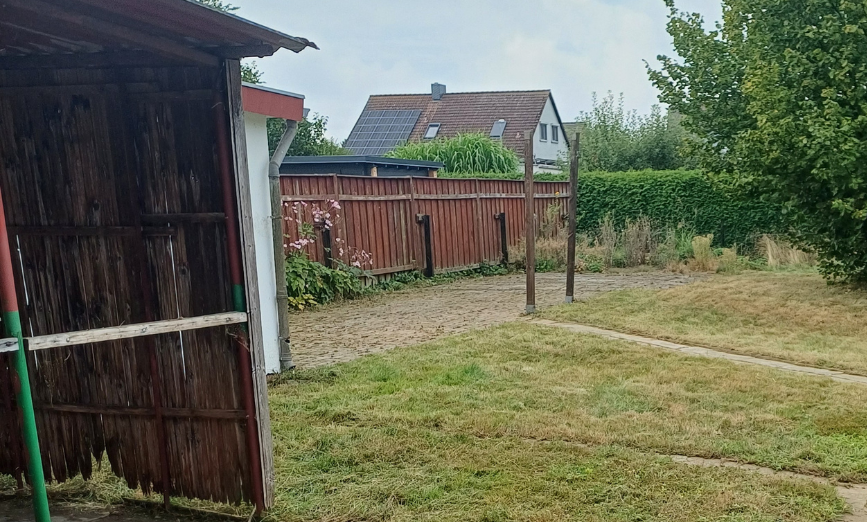Gartenanlage nach Entfernung von Wildwuchs und frisch gemähtem hohem Gras
