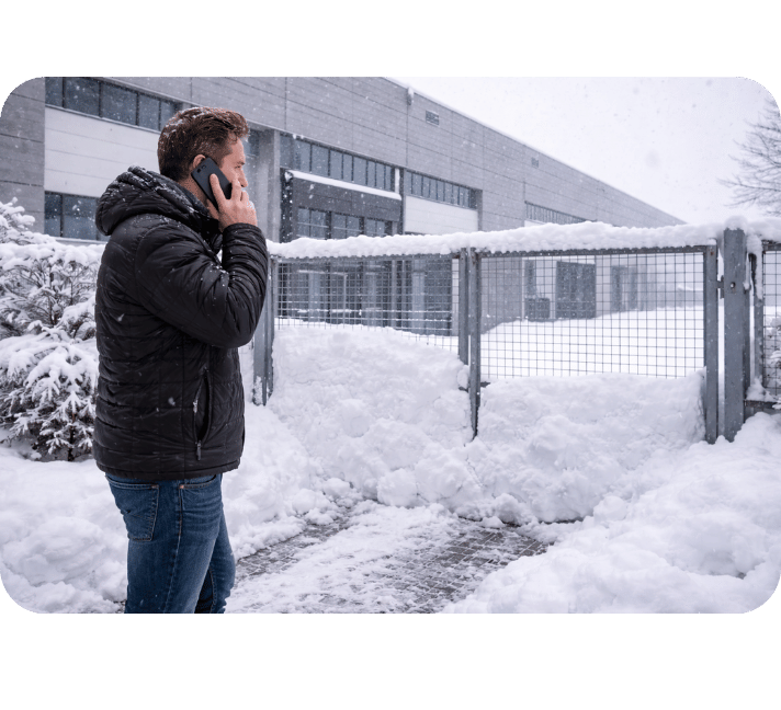 Besorgter Kunde vor verschneitem Tor ruft den Winter-Notdienst von SACO Haus und Garten in Salzgitter an